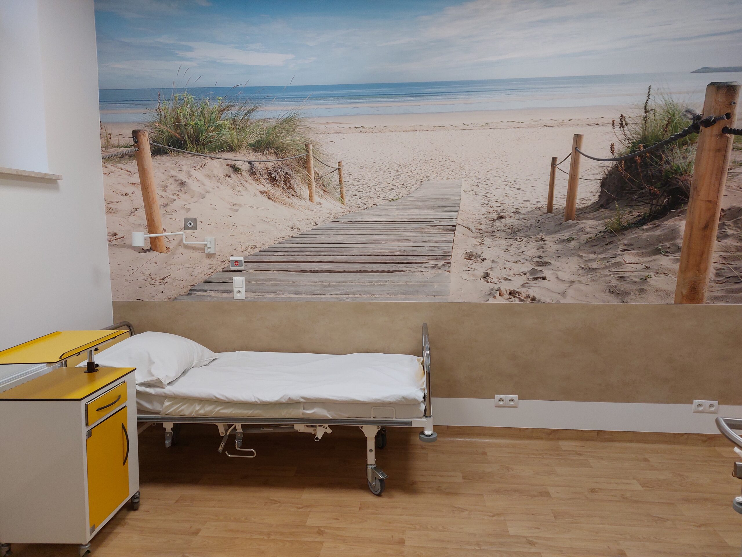 sala oddziału położniczego, łózko pobytowe, tapeta z plażą